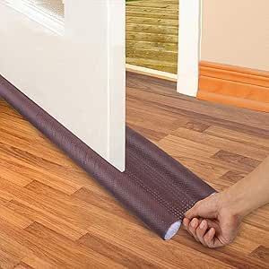 Person rolling out a brown floor protector strip on a wooden floor.